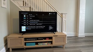 A flat-screen TV on a wooden stand with a cable box below it. - Best Location in AC! Near Boardwalk, Casino Action (Atlantic City)