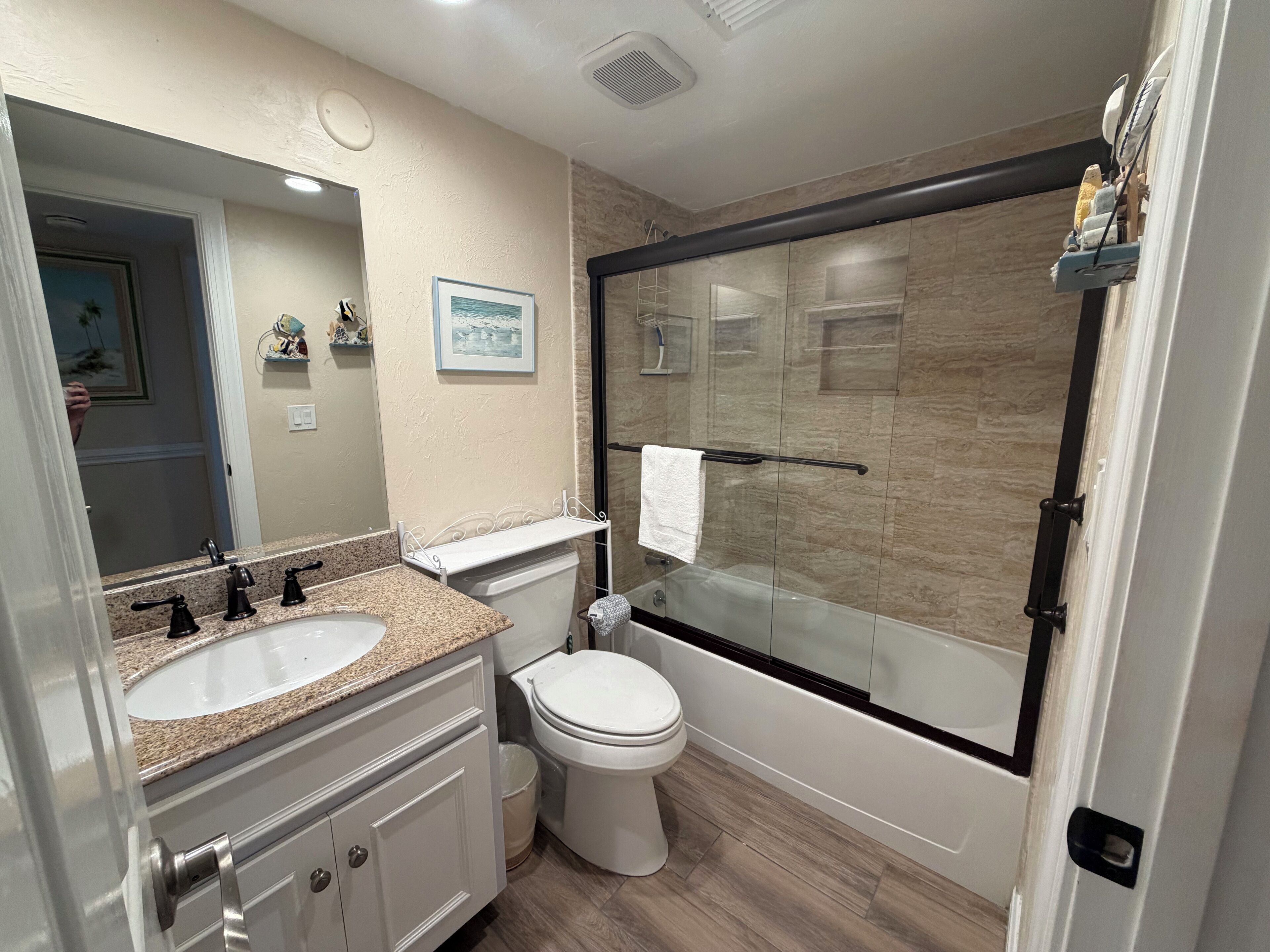 Une salle de bain moderne avec deux lavabos, des toilettes et une douche à parois de verre.