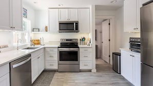 Een moderne keuken met witte kasten, roestvrijstalen apparatuur en een centraal eiland.