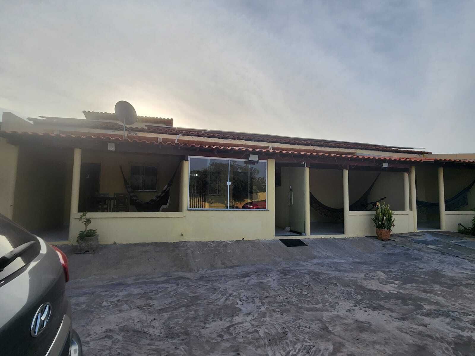 Un edificio de dos plantas con tejado de baldosas, amplias ventanas y un porche cubierto.
