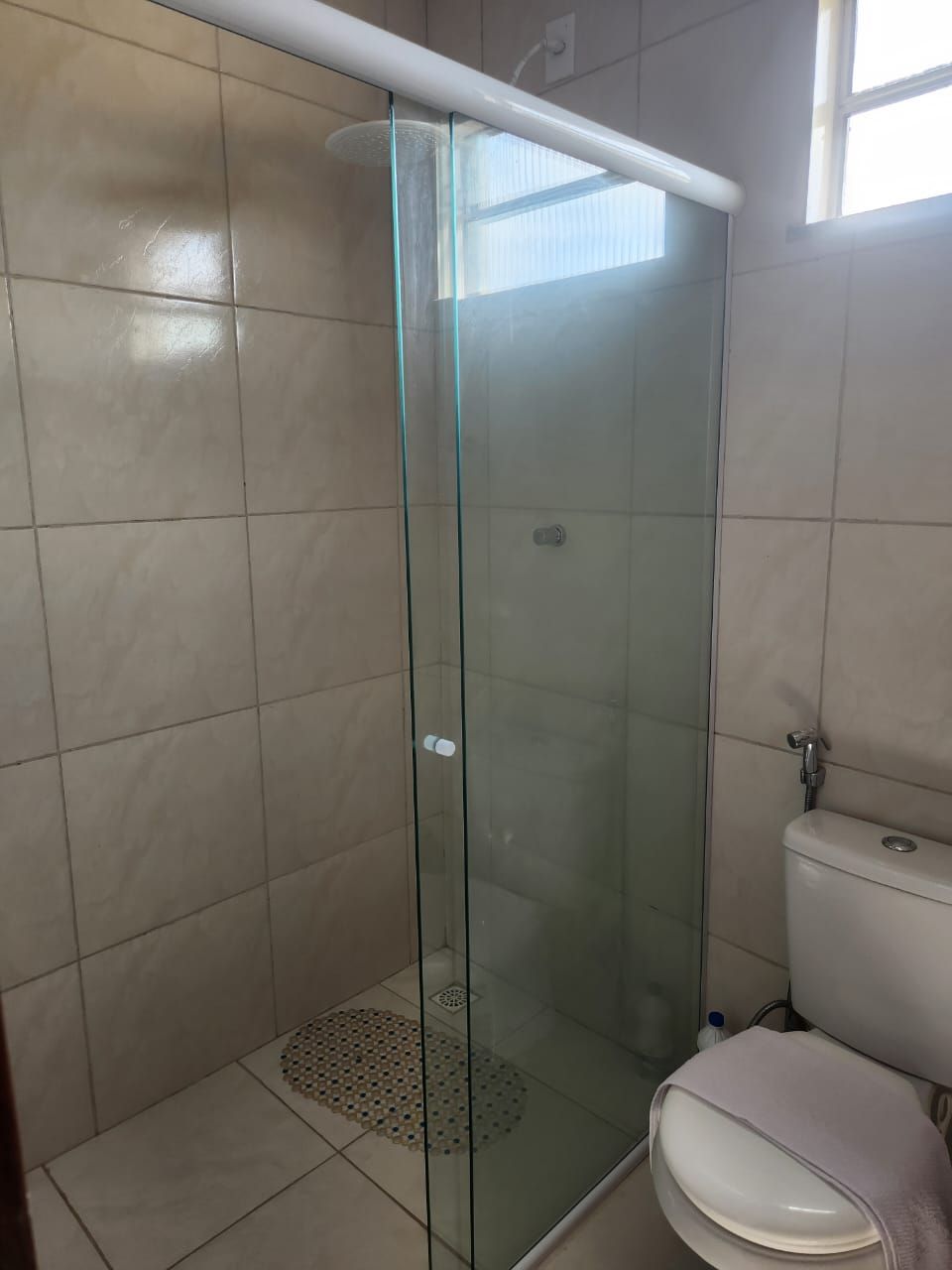 A glass-enclosed shower stall with a white toilet next to it.