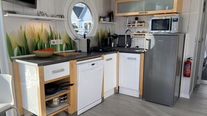 Una cuina moderna amb rentaplats, microones i finestra amb vista a una casa.
