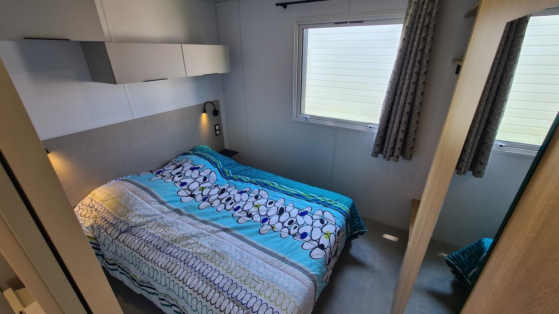 A compact bedroom with a bed, a window, and a headboard.