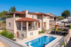 Un edificio de varios pisos con piscina, balcones y un tobogán pequeño.