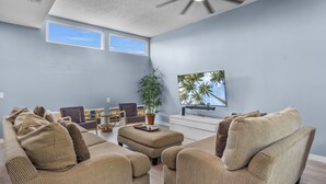 A living room with a sofa set, a coffee table, a TV, and a ceiling fan.