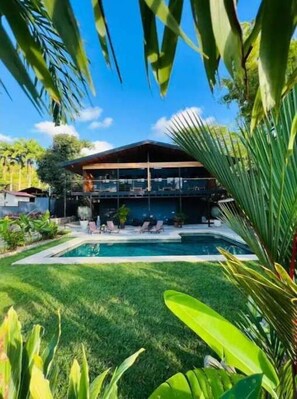 Relax by the pool surrounded by lush greenery and lounge chairs.