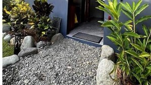 A traditional Japanese-style building with a wooden exterior, a gravel pathway, and a small garden with rocks and plants. - Villas Bodhi Soul Entero - Container Home and 2 Apartments - Saltwater Pool  (Savegre de Aguirre)