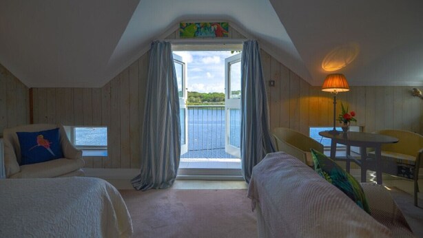 A room with two beds, a table, chairs, a lamp, and a view of the outdoors. - The Quay House, Clifden’s oldest building (Clifden)