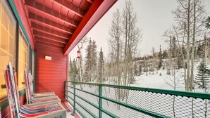 Een rood gebouw met een balkon met uitzicht op een besneeuwd landschap.