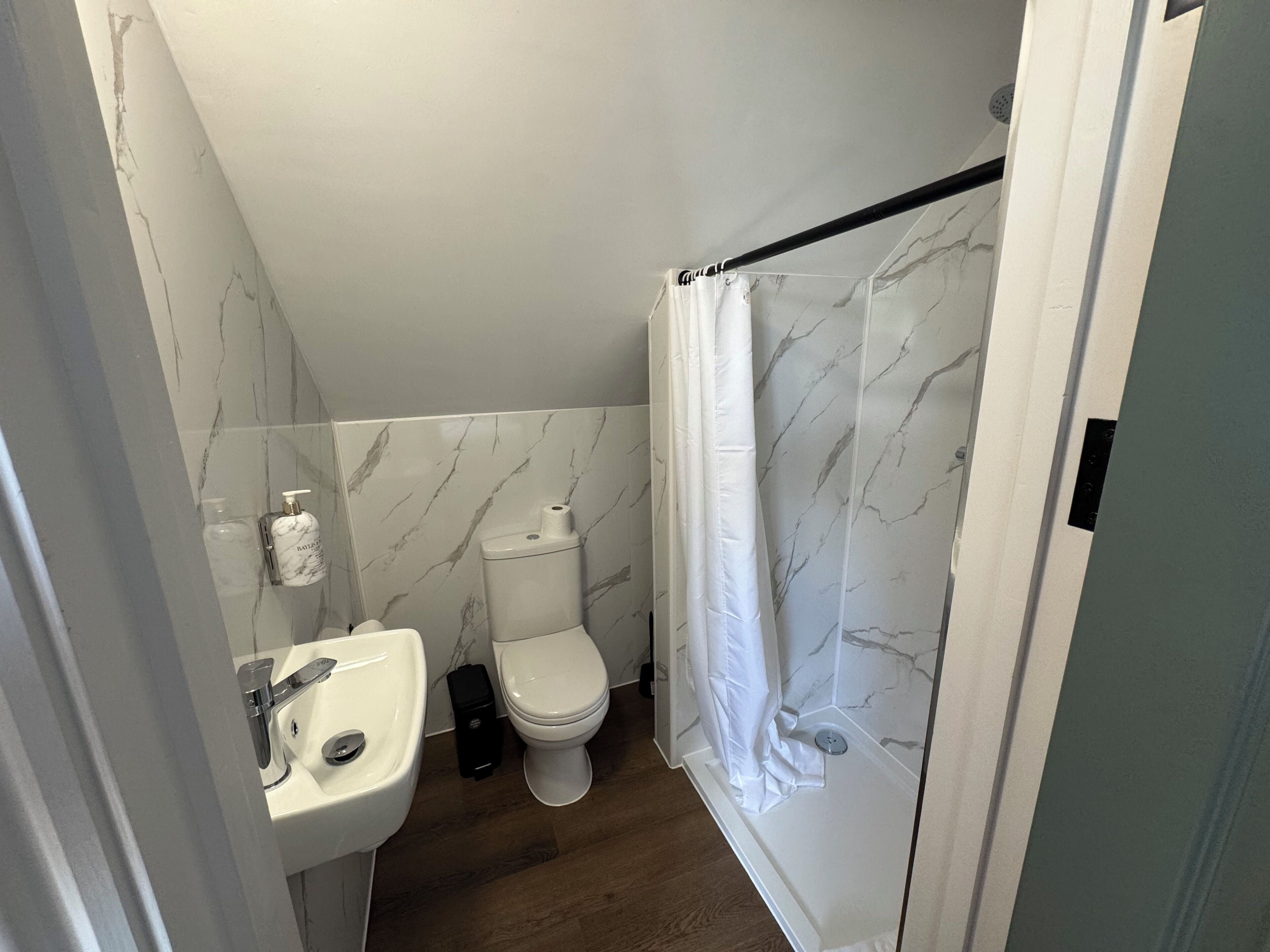 A bathroom with a toilet, sink, and shower curtain.