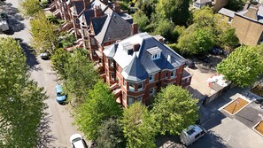 A residential area with a prominent red brick house featuring a gabled roof and multiple windows. - Charlie Hotel (London)