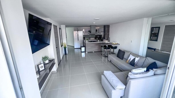 Een moderne woonkamer met een bank en een eethoek.