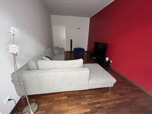 Relax in this stylish living room with a comfortable sofa, floor lamp, and flat-screen TV.