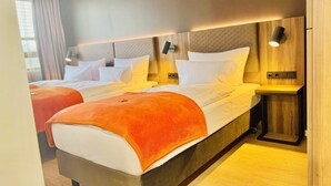 A modern hotel room with a large bed, two bedside tables, and a headboard with integrated lighting. - Trip Inn Hotel Frankfurt-Heusenstamm (Heusenstamm)