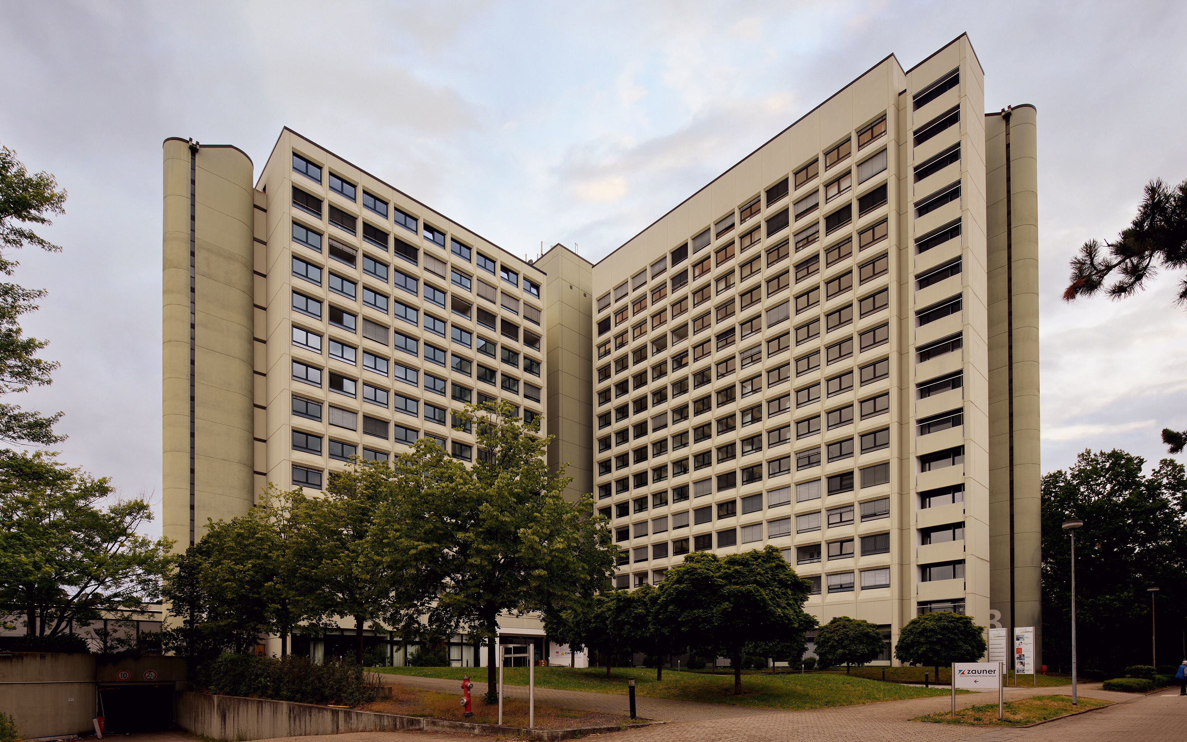 Un grand bâtiment moderne, doté de nombreux étages et d’une architecture symétrique.