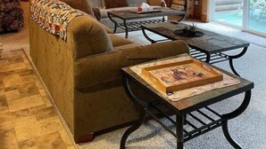 Un interior de cabaña acogedor con sofá, mesa de centro y estanterías.