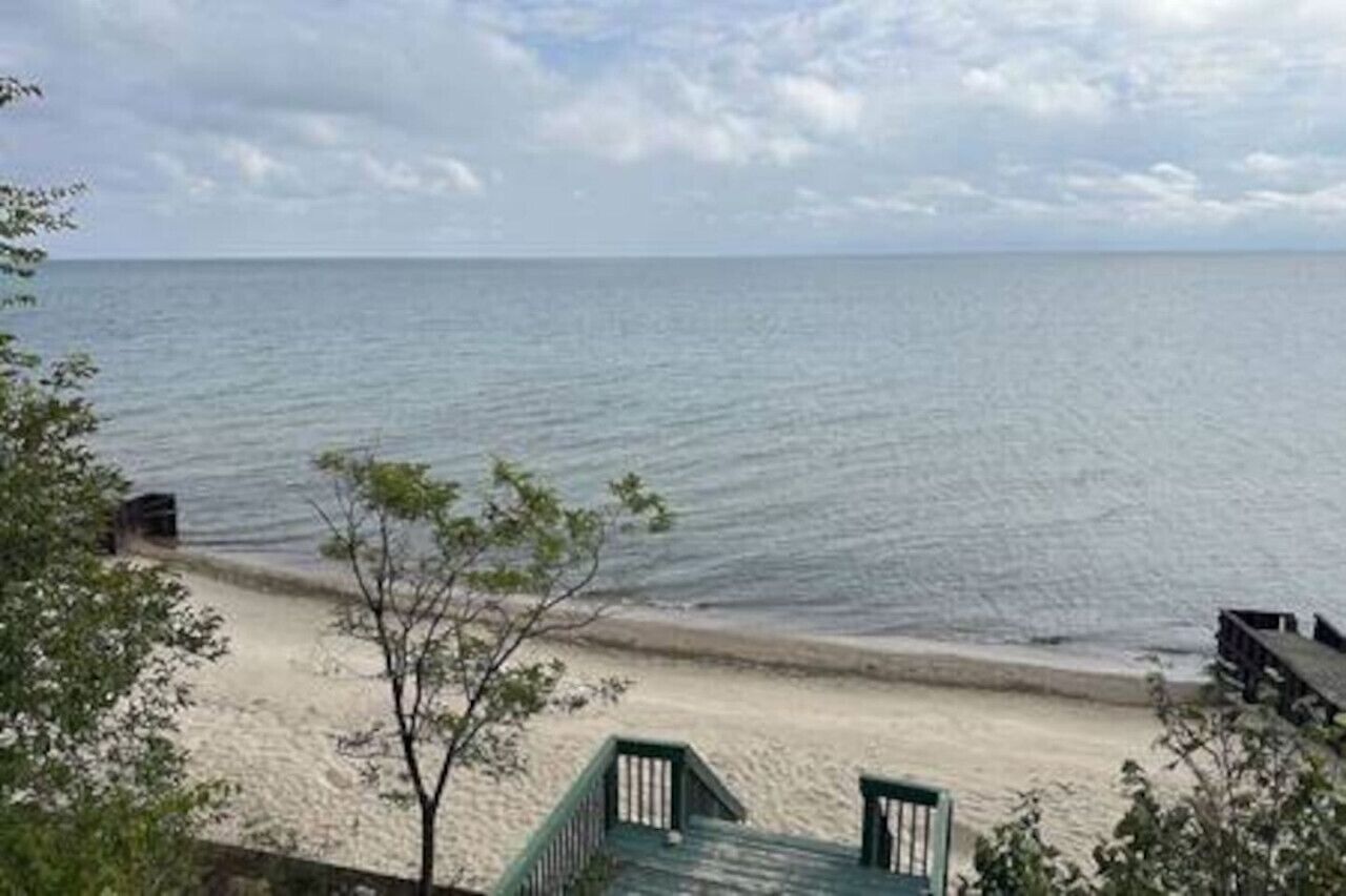 A beach with a wooden walkway leading to a sandy shore.