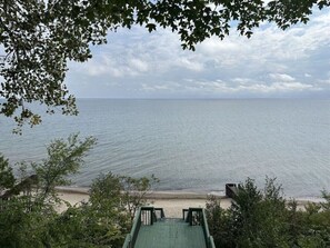 Une vue sur la plage avec une terrasse en bois et un bâtiment au premier plan.