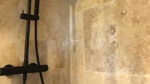 A shower with a handheld showerhead mounted on a wall. - The Hobbit du Domaine de la Calotine (Dives-sur-Mer)