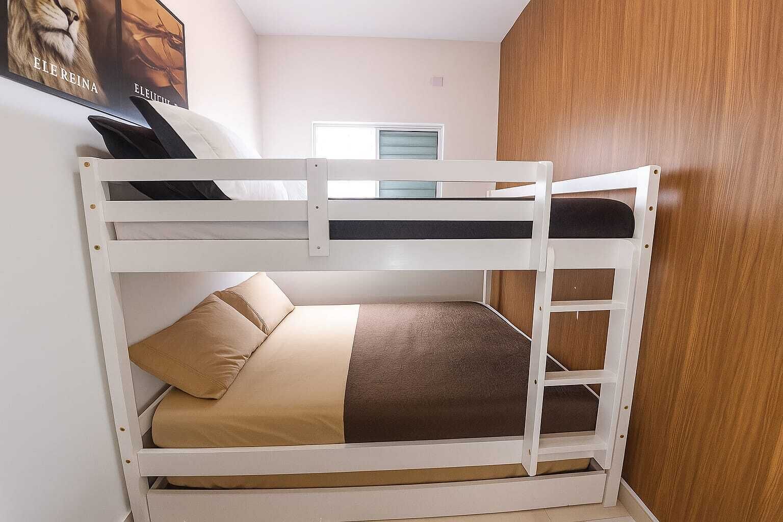 Una cama litera con una cama inferior y una ventana encima.