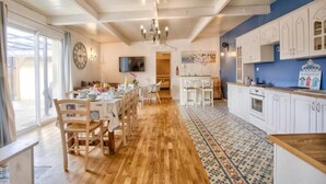 Une cuisine spacieuse avec des meubles blancs, un plan de travail en bois et un tapis à motifs.