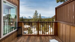 A wooden balcony with a view of snow-capped mountains and pine trees. - Entire Townhouse in Lake Village with Stunning Lake View! (Glenbrook)