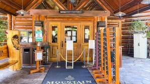 A wooden lodge entrance with a sign for Mountain Lodge, a hand sanitizer dispenser, and a wooden rack with items. - 2 BR Condominium - Luxury ski-in/ski-out (rare find) (Telluride)