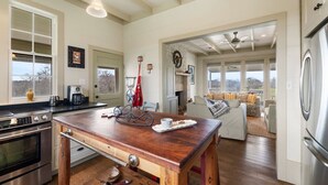 Une cuisine spacieuse dotée de plans de travail en bois, d’appareils électroménagers en acier inoxydable et d’un coin repas avec une table en bois.