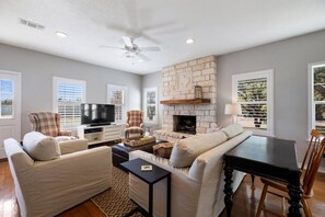 A living room with a fireplace, a television, and a dining table.
