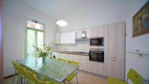 A modern kitchen with a dining area, featuring a table with chairs, a microwave, oven, and a sink.