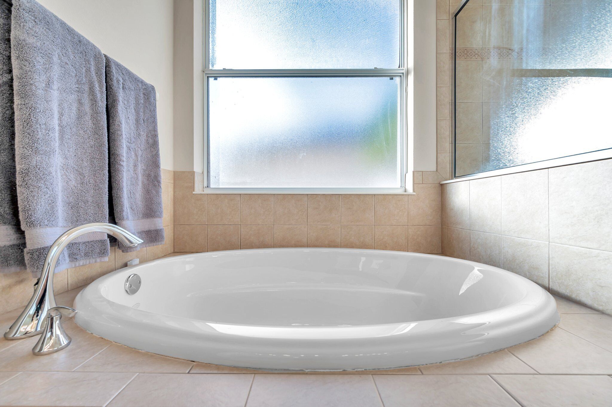 Une salle de bain avec une baignoire, une fenêtre et un espace douche.