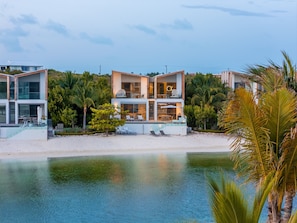 Ein modernes, zweistöckiges Strandhaus mit Pool, Sitzgelegenheiten im Freien und Blick aufs Meer.