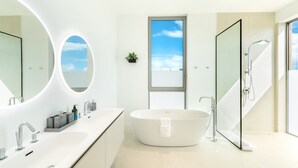 Une salle de bain moderne avec une baignoire sur pieds, un grand miroir et une cabine de douche en verre.