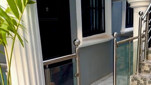 Un escalier avec des marches en pierre, une rambarde en verre et une plante en pot.