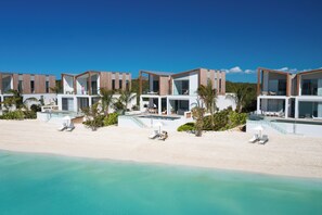 A beachfront resort with modern architecture, a pool, and beachside amenities. - Lagoon Villa 3 Bedroom LV14 (Providenciales)