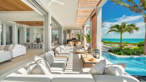 Un espacio habitable moderno y abierto con piscina y vista al océano.