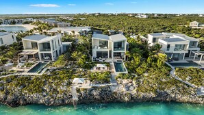 Une station balnéaire dotée de villas modernes, d’une piscine et d’un littoral rocheux.