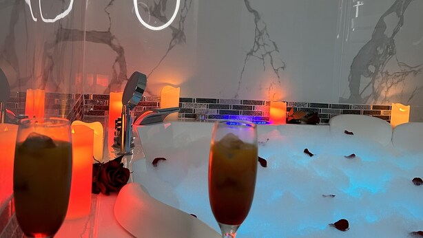 Ein modernes Interieur mit Marmorwand, Billardtisch und Kerzen.