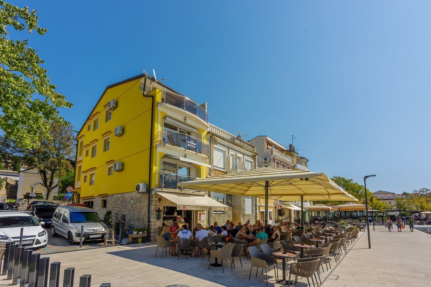 Un edificio amarillo con terraza y zona cubierta.