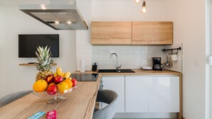 A modern kitchen with wooden cabinets, a black countertop, and a fruit bowl. - Luxury with pool, sauna, whirlpool directly by the sea (Novi Vinodolski)