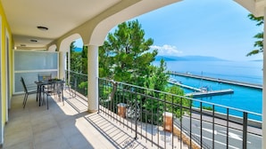 Ein Balkon mit Blick auf einen Yachthafen und das Meer.