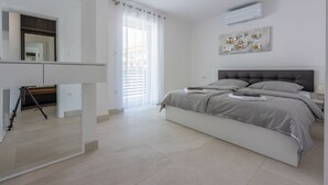 A modern bedroom with a large bed, a mirror, and a tripod in the corner. - 500 metres to the beach with pool, sea view (Crikvenica)