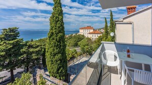 A balcony with a table, chairs, and a bottle of wine. - 500 metres to the beach with pool, sea view (Crikvenica)