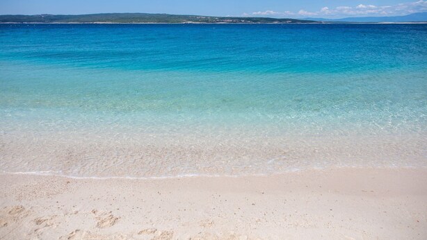 A beach with clear turquoise water and a sandy shore. - 500 metres beach with pool (Crikvenica)