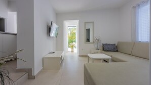 A modern living room with a sofa, a coffee table, and a TV mounted on the wall. - 500 metres beach with pool (Crikvenica)