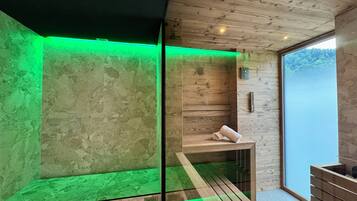 Un bagno moderno con pareti in legno, cabina doccia in vetro e una panca con asciugamani.