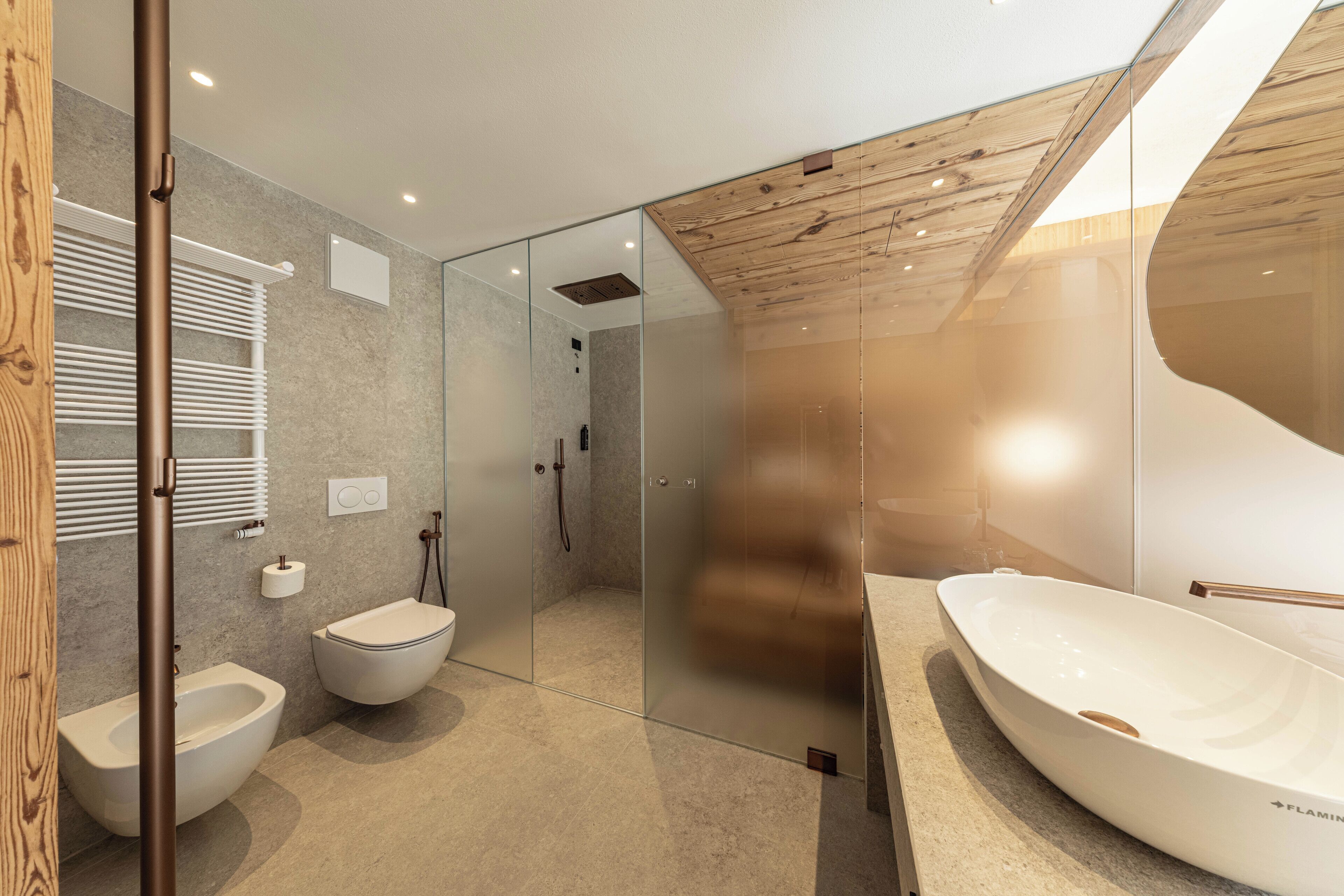 Un baño moderno con ducha acristalada, lavabo blanco y bidé.
