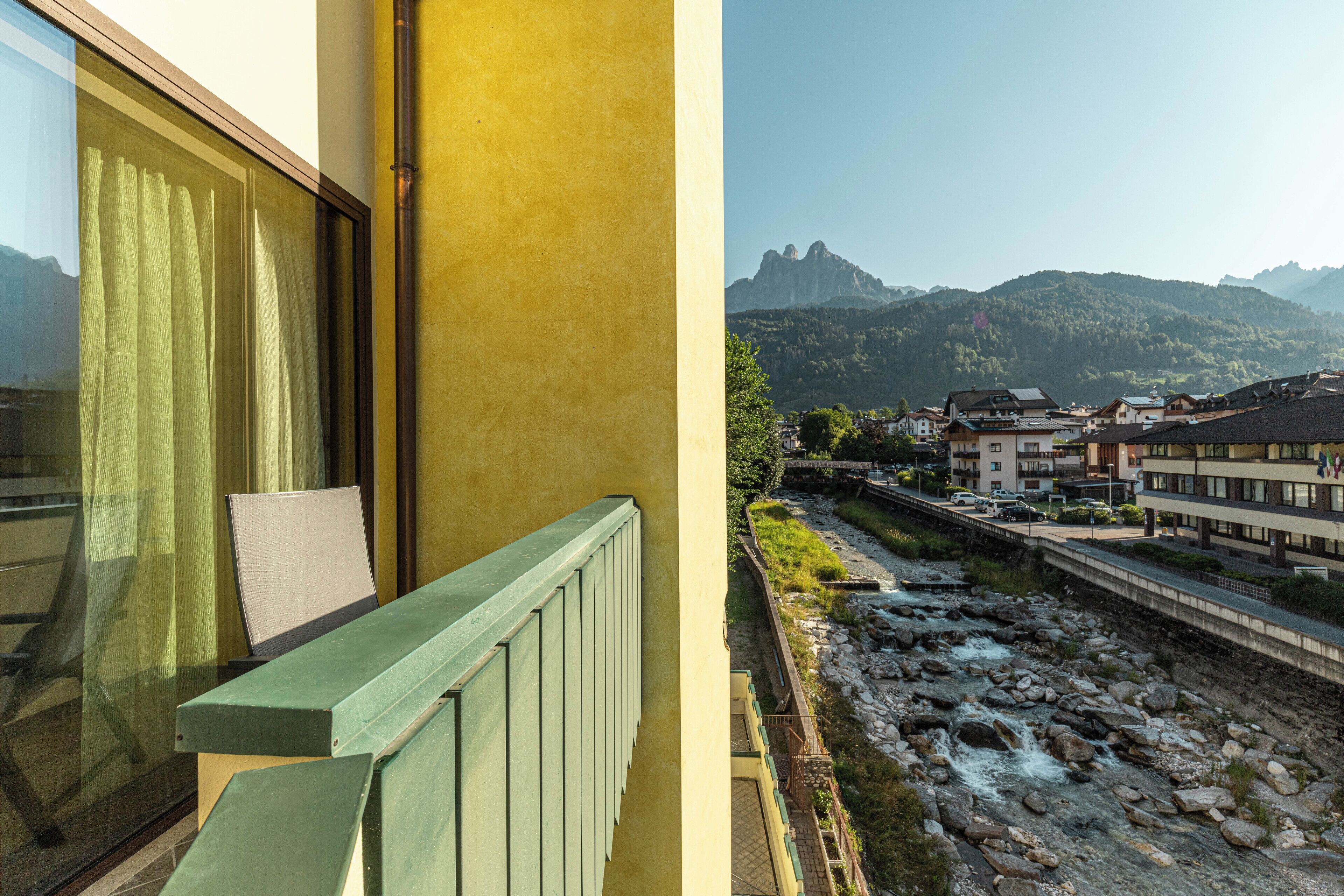 Un balcón con vistas a un río y montañas.
