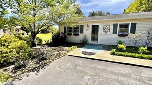 A single-story house with a front porch, a small garden, and a visible mailbox. - Parkers Flat 147, Comfy and Cozy.  Fully Furnished , Sparkling Clean . (Aiken)