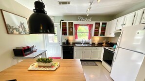 A kitchen with white cabinets, a black pendant light, a sink, and a refrigerator. - Parkers Flat 147, Comfy and Cozy.  Fully Furnished , Sparkling Clean . (Aiken)